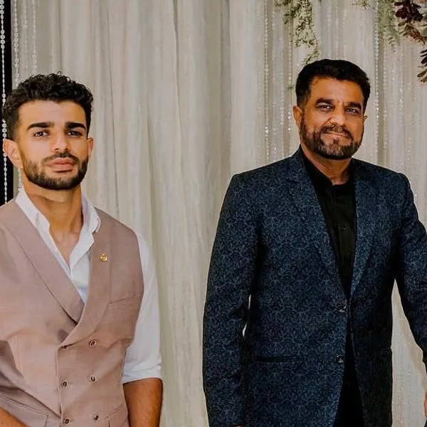 Two men of a family, in a tan waistcoat and a navy jacquard jacket