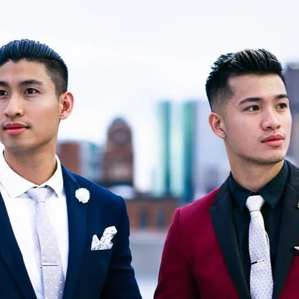 Two men, one in a navy suit, one in burgundy with a black lapel